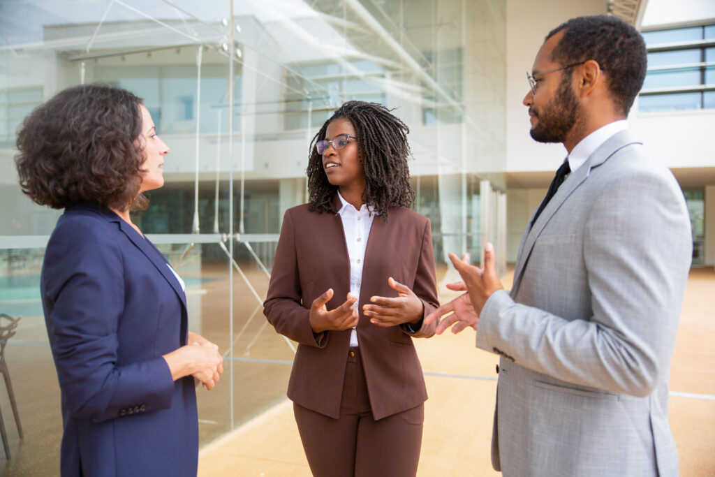 multiethnic coworkers standing and talking
